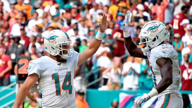 Oct 13, 2019; Miami Gardens, FL, USA; Miami Dolphins quarterback Ryan Fitzpatrick (left) greets wide receiver DeVante Parker (right) on a touchdown catch against the Washington Redskins during the second half at Hard Rock Stadium. Mandatory Credit: Steve Mitchell-USA TODAY Sports