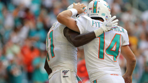 Oct 13, 2019; Miami Gardens, FL, USA; Miami Dolphins quarterback Ryan Fitzpatrick (14) celebrates with Miami Dolphins wide receiver DeVante Parker (11) after scoring a touchdown in the fourth quarter of the game against the Washington Redskins at Hard Rock Stadium. Mandatory Credit: Sam Navarro-USA TODAY Sports