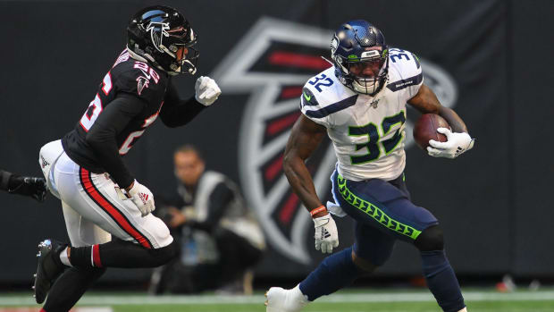 Seattle Seahawks running back Chris Carson (32) runs against Atlanta Falcons cornerback Isaiah Oliver (26) during the first quarter at Mercedes-Benz Stadium. Mandatory Credit: Dale Zanine-USA TODAY Sports