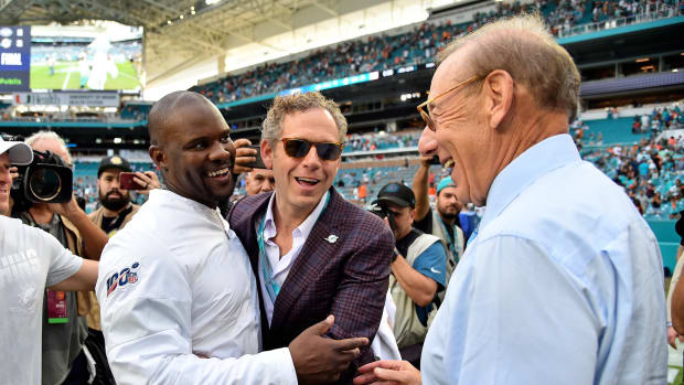 Coach Brian Flores is congratulated by Dolphins owner Steve Ross after his first win for Miami against the Jets.