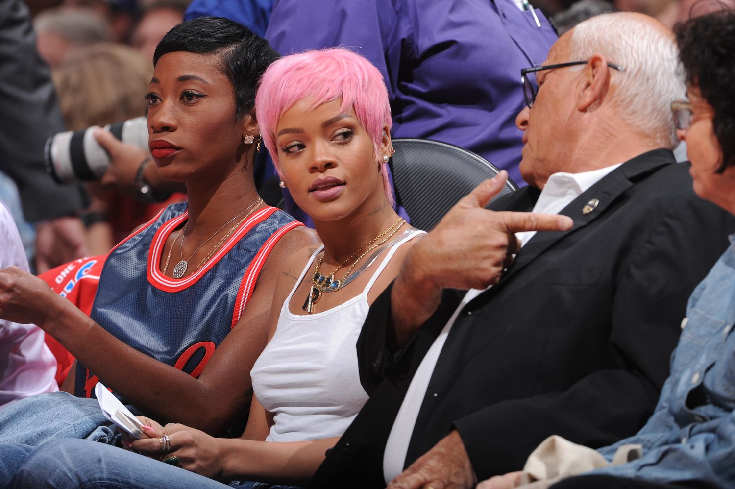 Rihanna at a basketball game with pink hair