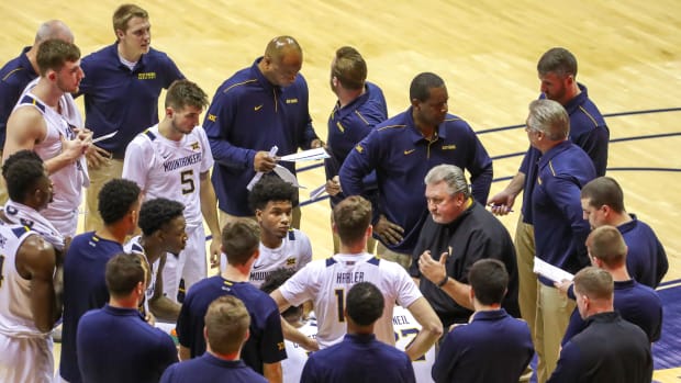 West Virginia Mountaineers head coach Bob Huggins talks with his team during a timeout during the first half against the Rhode Island Rams at WVU Coliseum.