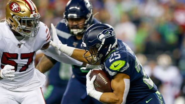 Seattle Seahawks running back Travis Homer (25) stiff-arms San Francisco 49ers linebacker Dre Greenlaw (57) on a rushing attempt during the first quarter at CenturyLink Field.