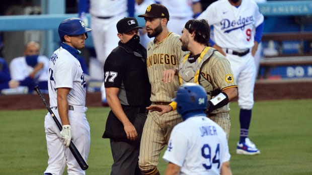 August 11, 2020; Los Angeles, California, USA; San Diego Padres first baseman Eric Hosmer (30) separates catcher Austin Hedges (18) and Los Angeles Dodgers catcher Austin Barnes (15) following the second inning at Dodger Stadium. Mandatory Credit: Gary A. Vasquez-USA TODAY Sports