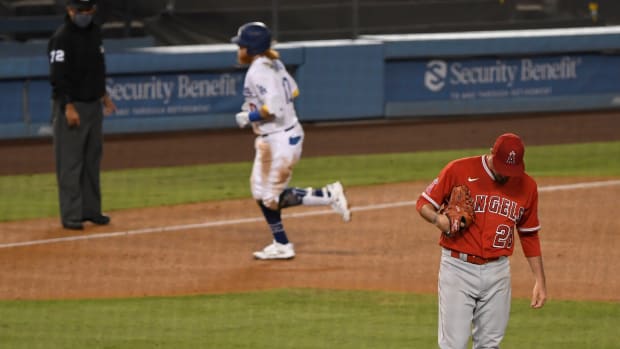 Sep 25, 2020; Los Angeles, California, USA; Los Angeles Angels starting pitcher Andrew Heaney (28) reacts after giving up a solo homer to Los Angeles Dodgers third baseman Justin Turner (background) in the fifth inning at Dodger Stadium. Mandatory Credit: Robert Hanashiro-USA TODAY Sports