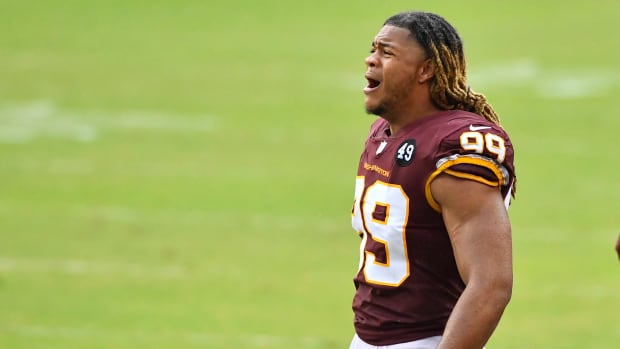 Oct 11, 2020; Landover, Maryland, USA; Washington Football Team defensive end Chase Young (99) cheers from the sidelines against the Los Angeles Rams during the second half at FedExField.