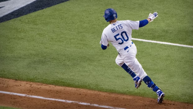 Oct 20, 2020; Arlington, Texas, USA; Los Angeles Dodgers right fielder Mookie Betts (50) hits a home run against the Tampa Bay Rays during the sixth inning in game one of the 2020 World Series at Globe Life Field. Mandatory Credit: Jerome Miron-USA TODAY Sports