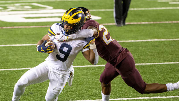 Michigan's Chris Evans is talked by a Minnesota defender in Week 1