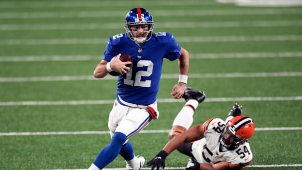 New York Giants quarterback Colt McCoy (12) breaks a tackle by Cleveland Browns defensive end Olivier Vernon (54) during a game at MetLife Stadium on Sunday, December 20, 2020, in East Rutherford.