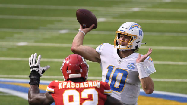 Sep 20, 2020; Inglewood, California, USA; Los Angeles Chargers quarterback Justin Herbert (10) throws a pass against Kansas City Chiefs defensive end Tanoh Kpassagnon (92) during the third quarter at SoFi Stadium. Mandatory Credit: Robert Hanashiro-USA TODAY Sports