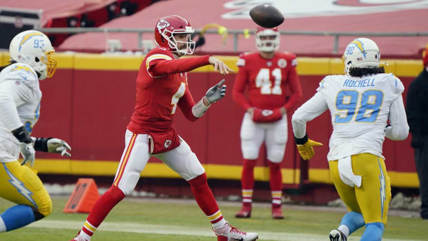 Jan 3, 2021; Kansas City, Missouri, USA; Kansas City Chiefs quarterback Chad Henne (4) throws a pass on the run against Los Angeles Chargers defensive tackle Justin Jones (93) and defensive end Isaac Rochell (98) during the first half at Arrowhead Stadium. Mandatory Credit: Jay Biggerstaff-USA TODAY Sports