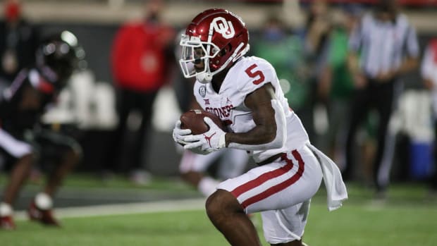 Oct 31, 2020; Lubbock, Texas, USA; Oklahoma Sooners running back TJ Pledger (5) rushes against the Texas Tech Red Raiders in the first half at Jones AT&T Stadium.