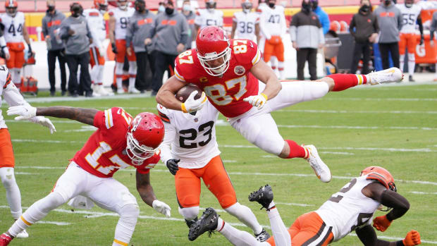 Jan 17, 2021; Kansas City, Missouri, USA; Kansas City Chiefs tight end Travis Kelce (87) leaps over Cleveland Browns strong safety Karl Joseph (42) to score a touchdown during the first half in the AFC Divisional Round playoff game at Arrowhead Stadium. Mandatory Credit: Denny Medley-USA TODAY Sports