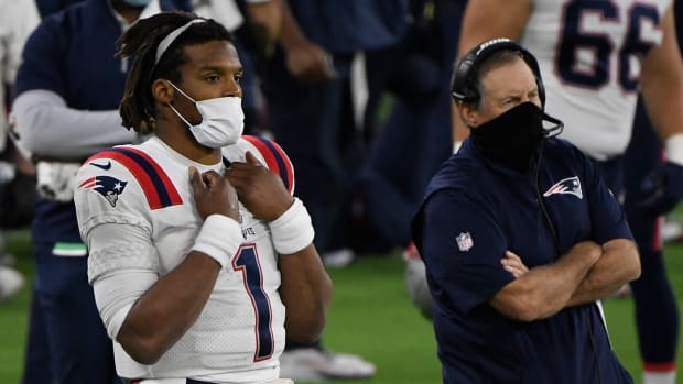 Cam Newton looks on from the sidelines with head coach Bill Belichick