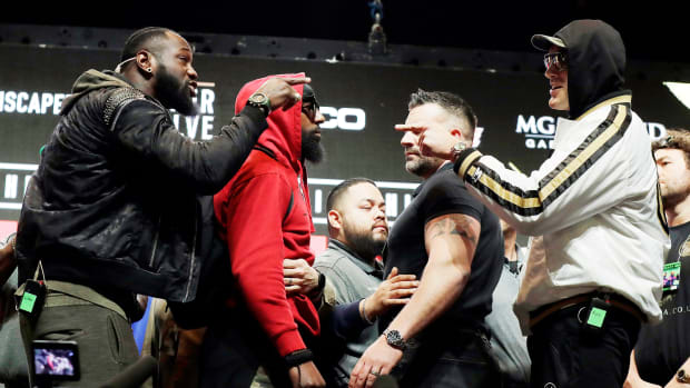 Deontay Wilder and Tyson Fury point fingers at each other during a shoving match their pre-fight weigh-in