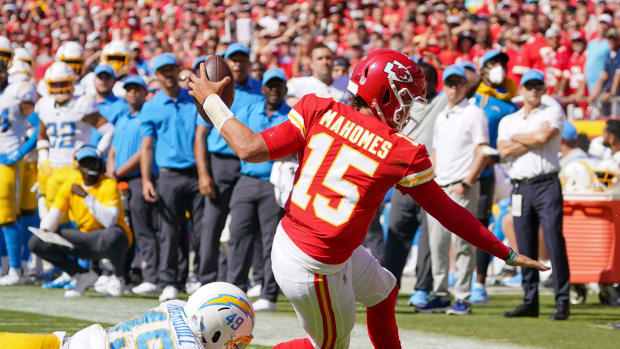 Sep 26, 2021; Kansas City, Missouri, USA; Kansas City Chiefs quarterback Patrick Mahomes (15) runs the ball and is tackled by Los Angeles Chargers linebacker Drue Tranquill (49) during the second half at GEHA Field at Arrowhead Stadium. Mandatory Credit: Denny Medley-USA TODAY Sports
