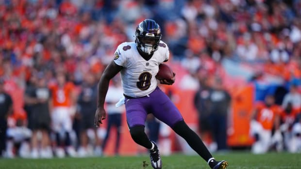 Oct 3, 2021; Denver, Colorado, USA; Baltimore Ravens quarterback Lamar Jackson (8) carries the ball in the third quarter against the Denver Broncos at Empower Field at Mile High. Mandatory Credit: Ron Chenoy-USA TODAY Sports