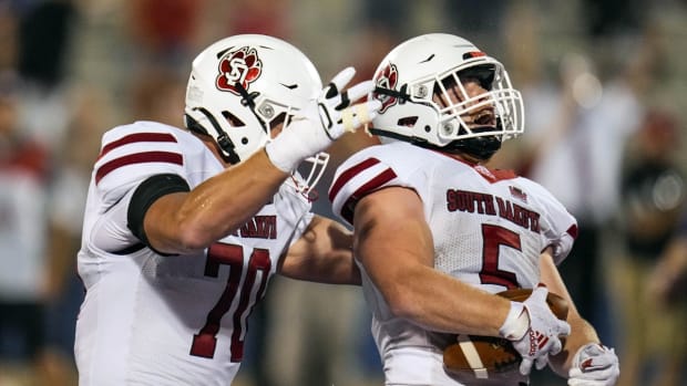 Sep 3, 2021; Lawrence, Kansas, USA; South Dakota Coyotes running back Travis Theis (5) celebrates with offensive lineman Alex Jensen (70) after scoring a touchdown against the Kansas Jayhawks during the second half at David Booth Kansas Memorial Stadium. Mandatory Credit: Jay Biggerstaff-USA TODAY Sports