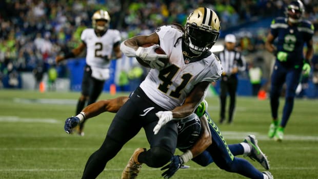 NFL: New Orleans Saints at Seattle Seahawks Oct 25, 2021; Seattle, Washington, USA; New Orleans Saints running back Alvin Kamara (41) breaks a tackle by Seattle Seahawks defensive back Ryan Neal (26) to score a touchdown on a reception during the second quarter at Lumen Field. Mandatory Credit: Joe Nicholson-USA TODAY Sports