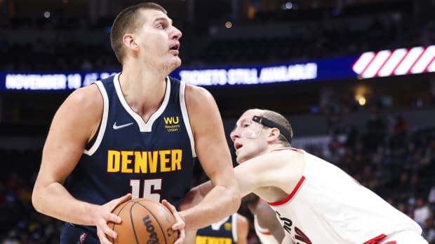 Nov 14, 2021; Denver, Colorado, USA; Denver Nuggets center Nikola Jokic (15) goes up for a shot over Portland Trail Blazers center Cody Zeller (40) in the first quarter at Ball Arena. Mandatory Credit: Michael Ciaglo-USA TODAY Sports