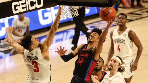 Mar 4, 2021; Richmond, Virginia, USA; Duquesne Dukes forward Chad Baker (44) shoots the ball as Richmond Spiders forward Tyler Burton (3) defends in the second half in the second round of the 2021 Atlantic 10 Conference Tournament at Stuart C. Siegel Center. Mandatory Credit: Geoff Burke-USA TODAY Sports
