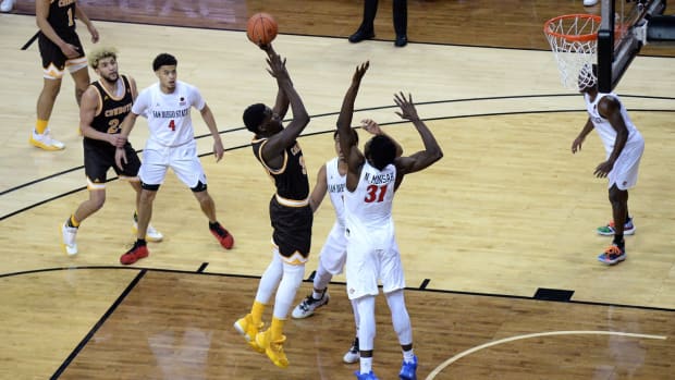 Mar 11, 2021; Las Vegas, Nevada, USA; Wyoming Cowboys forward Graham Ike (33) shoots the ball over San Diego State Aztecs forward Nathan Mensah (31) during the second half at the Thomas &amp; Mack Center. Mandatory Credit: Orlando Ramirez-USA TODAY Sports