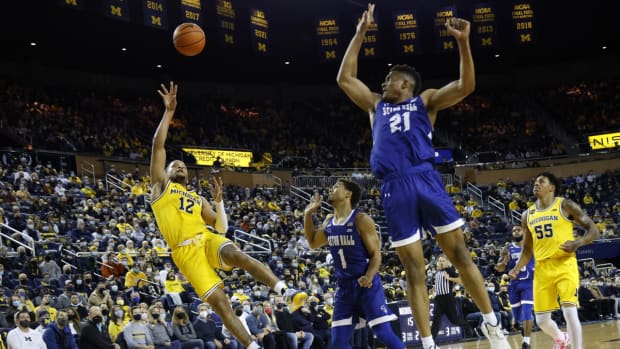 Nov 16, 2021; Ann Arbor, Michigan, USA; Michigan Wolverines guard DeVante' Jones (12) shoots over Seton Hall Pirates guard Bryce Aiken (1) and center Ike Obiagu (21) in the first half at Crisler Center. Mandatory Credit: Rick Osentoski-USA TODAY Sports