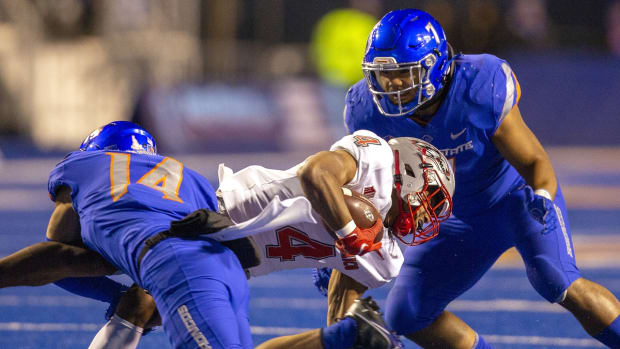 Nov 20, 2021; Boise, Idaho, USA; New Mexico Lobos running back Bobby Wooden (4) is tackled by Boise State Broncos cornerback Kaonohi Kaniho (14) and linebacker Ezekiel Noa (7) during the first half at Albertsons Stadium. Mandatory Credit: Brian Losness-USA TODAY Sports
