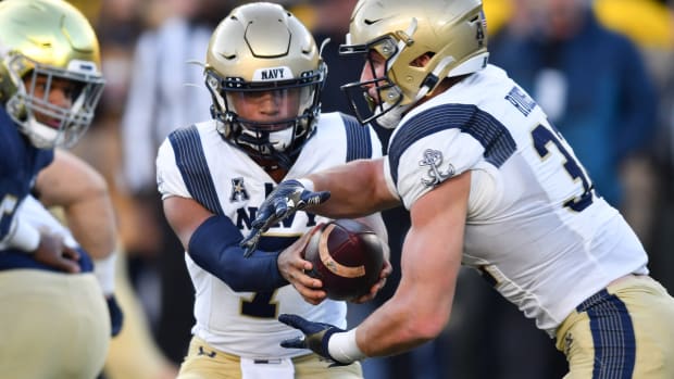 Nov 6, 2021; South Bend, Indiana, USA; Navy Midshipmen quarterback Xavier Arline (7) hands off to Navy Midshipmen running back Isaac Ruoss (32) in the third quarter against the Notre Dame Fighting Irish at Notre Dame Stadium. Mandatory Credit: Matt Cashore-USA TODAY Sports