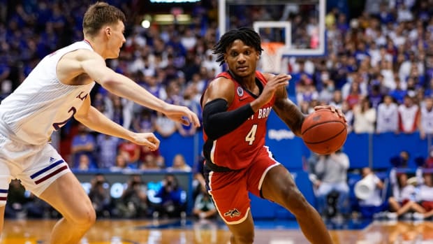 Nov 18, 2021; Lawrence, Kansas, USA; Stony Brook Seawolves guard Tykei Greene (4) drives against Kansas Jayhawks guard Christian Braun (2) during the first half at Allen Fieldhouse. Mandatory Credit: Jay Biggerstaff-USA TODAY Sports
