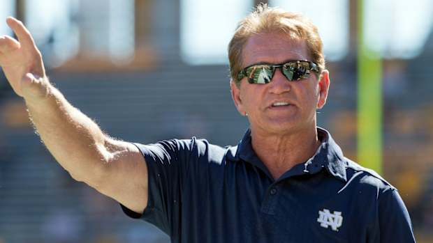 Joe Theismann walks on the field.