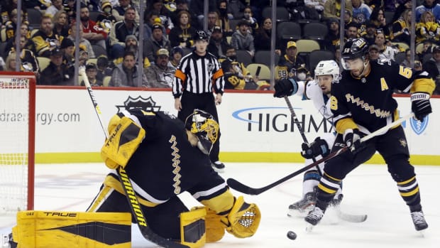 Jan 2, 2022; Pittsburgh, Pennsylvania, USA; Pittsburgh Penguins goaltender Casey DeSmith (1) makes a save as defenseman Kris Letang (58) defends San Jose Sharks center Logan Couture (39) during the third period at PPG Paints Arena. The Penguins won 8-5. Mandatory Credit: Charles LeClaire-USA TODAY Sports