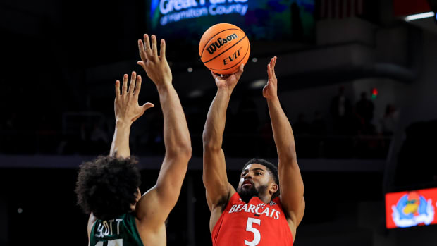 Jan 1, 2022; Cincinnati, Ohio, USA; Tulane Green Wave forward Quentin Scott (15) defends against Cincinnati Bearcats guard David DeJulius (5) in the second half at Fifth Third Arena. Mandatory Credit: Aaron Doster-USA TODAY Sports