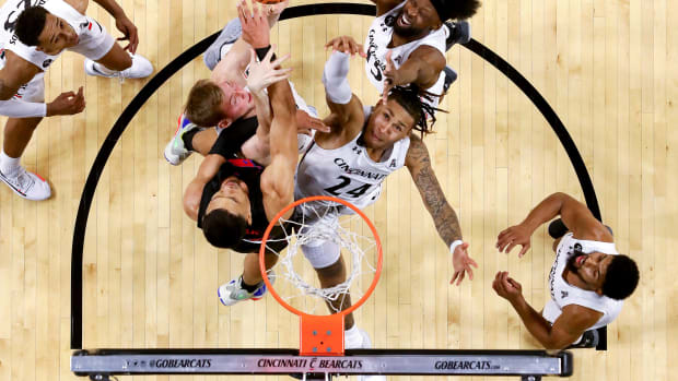 Cincinnati Bearcats guard Jeremiah Davenport (24), Cincinnati Bearcats center Hayden Koval (25) and Cincinnati Bearcats forward John Newman III (15) compete for a rebound against Southern Methodist Mustangs forward Tristan Clark (25) in the first half of an NCAA men s college basketball game, Thursday, Jan. 6, 2022, at Fifth Third Arena in Cincinnati. The Cincinnati Bearcats defeated the Southern Methodist Mustangs, 77-60. Southern Methodist Mustangs At Cincinnati Bearcats Jan 6 Smu