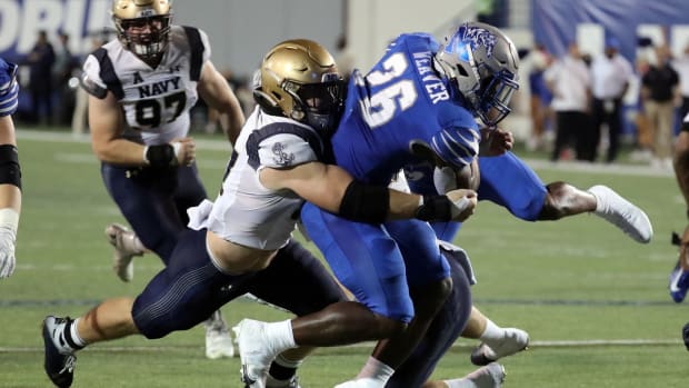 Oct 14, 2021; Memphis, Tennessee, USA; Memphis Tigers running back Marquavius Weaver (26) runs the ball for a first down as Navy Midshipmen linebacker Johnny Hodges (57) makes the tackle during the second half at Liberty Bowl