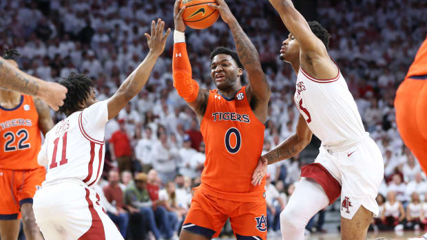 Feb 8, 2022; Fayetteville, Arkansas, USA; Auburn Tigers guard K.D. Johnson (0) drives to the basket in the first half as Arkansas Razorbacks guards Chris Lykes (11) Au'Diese Toney (5) defend at Bud Walton Arena. Mandatory Credit: Nelson Chenault-USA TODAY Sports