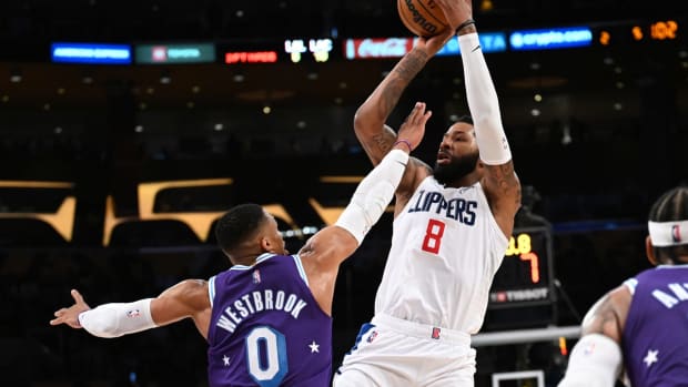 Feb 25, 2022; Los Angeles, California, USA;  Los Angeles Clippers forward Marcus Morris Sr. (8) hits a three point basket over Los Angeles Lakers guard Russell Westbrook (0) in the fourth quarter of the game at Crypto.com Arena. Mandatory Credit: Jayne Kamin-Oncea-USA TODAY Sports