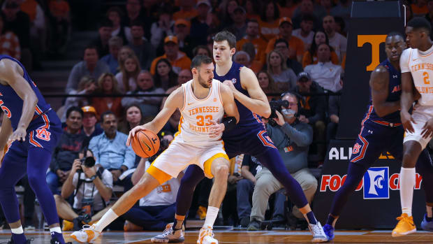 Feb 26, 2022; Knoxville, Tennessee, USA; Tennessee Volunteers forward Uros Plavsic (33) moves the ball against Auburn Tigers forward Walker Kessler (13) during the first half at Thompson-Boling Arena. Mandatory Credit: Randy Sartin-USA TODAY Sports