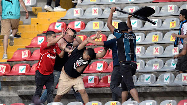 Supporters of Atlas fight with supporters of Queretaro during the Mexican Clausura tournament football match between Queretaro and Atlas at Corregidora stadium in Queretaro, Mexico on March 5, 2022. - A match between Mexican football clubs was called off March 5, 2022 after violence by opposing fans spilled onto the field. The game between Queretaro and Atlas at La Corregidora stadium in the city of Queretaro -- the ninth round of the 2022 Clausura football tournament -- was in its 63rd minute when fights between opposing fans broke out.
