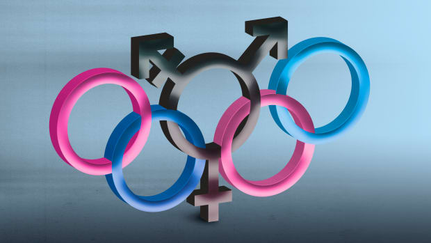 The Olympic rings in trans pride pink and blue with a black transgender symbol in the center ring