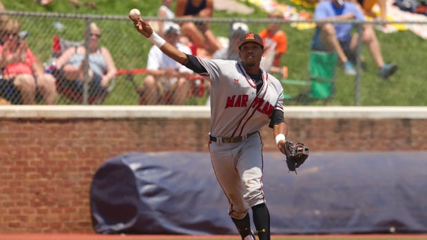 Jun 7, 2014; Charlottesville, VA, USA; Maryland Terrapins infielder Jose Cuas (12) attempts a throw to first base against the Virginia Cavaliers at Davenport Field. Mandatory Credit: Rafael Suanes-USA TODAY Sports