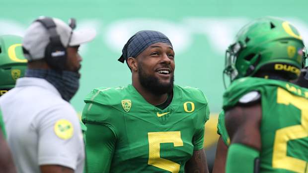 Oregon EDGE Kayvon Thibodeaux smiles on the sideline
