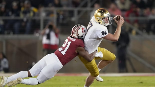 Stanford, California, USA; Stanford Cardinal safety Kendall Williamson (21) tackles Notre Dame Fighting Irish quarterback Jack Coan (17) during the first quarter at Stanford Stadium.