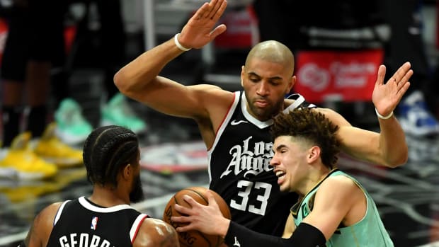 Mar 20, 2021; Los Angeles, California, USA; Charlotte Hornets guard LaMelo Ball (2) is fouled by Los Angeles Clippers guard Paul George (13) as Los Angeles Clippers forward Nicolas Batum (33) defends under the basket in the second half of the game at Staples Center. Mandatory Credit: Jayne Kamin-Oncea-USA TODAY Sports