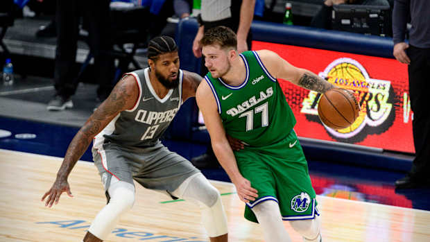 Mar 17, 2021; Dallas, Texas, USA; LA Clippers guard Paul George (13) and Dallas Mavericks guard Luka Doncic (77) in action during the game between the Dallas Mavericks and the LA Clippers at the American Airlines Center. Mandatory Credit: Jerome Miron-USA TODAY Sports