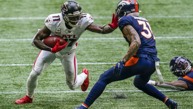 Nov 8, 2020; Atlanta, Georgia, USA; Atlanta Falcons wide receiver Julio Jones (11) runs against Denver Broncos safety Justin Simmons (31) after a catch during the first half at Mercedes-Benz Stadium. Mandatory Credit: Dale Zanine-USA TODAY Sports