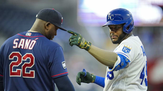 Jun 3, 2021; Kansas City, Missouri, USA; Kansas City Royals shortstop Hanser Alberto (49) gestures to the dugout after hitting a single as Minnesota Twins first baseman Miguel Sano (22) looks on during the fourth inning at Kauffman Stadium. Mandatory Credit: Jay Biggerstaff-USA TODAY Sports