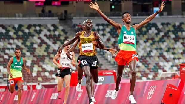 Selemon Barega crosses the finish line ahead of Joshua Cheptegei to win gold in the 10,000 meters at the Tokyo Olympics