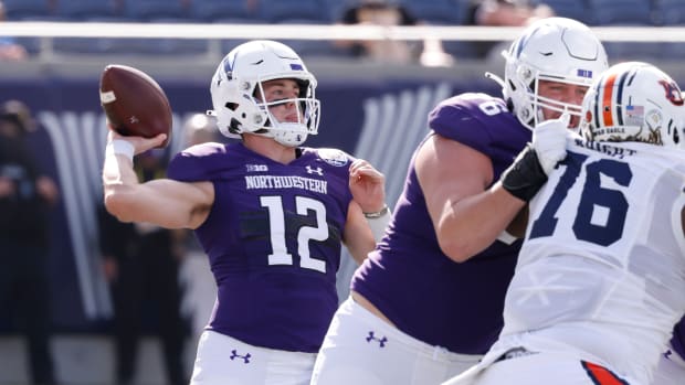 Northwestern Wildcats offensive lineman Ethan Wiederkehr (middle) blocks Auburn Tigers defensive tackle Jeremiah Wright (76) as Wildcats quarterback Peyton Ramsey (12) throws a pass during the first quarter at Camping World Stadium. Reinhold Matay-USA TODAY Sports
