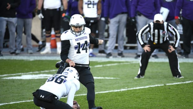 Northwestern Wildcats kicker Charlie Kuhbander (14) kicks a field goal as punter Derek Adams (36) holds the football during the second quarter against the Michigan State Spartans at Spartan Stadium. Tim Fuller-USA TODAY Sports